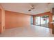 Open living room with tile floors, ceiling fan, and sliding glass doors leading to the backyard at 2932 Sweetgum S Way, Clearwater, FL 33761