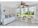Relaxing sunroom features daybed, ceiling fan, and bar-stool seating overlooking green space at 2960 59Th S St # 102, Gulfport, FL 33707