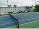 Tennis court with a net in a community with a parking lot in the background at 2960 59Th S St # 102, Gulfport, FL 33707