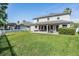 Expansive backyard with patio, green grass, white fence, and views of the home's exterior at 3211 Grassglen Pl, Wesley Chapel, FL 33544