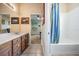 Well-lit bathroom featuring a shower-tub combo and vanity with drawers and decor at 3211 Grassglen Pl, Wesley Chapel, FL 33544