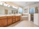 Bright bathroom featuring double vanity, soaking tub, and glass-enclosed shower with neutral tile surround at 3211 Grassglen Pl, Wesley Chapel, FL 33544