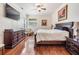 Primary bedroom featuring hardwood floors, ceiling fan, and large dresser at 3211 Grassglen Pl, Wesley Chapel, FL 33544