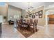Spacious dining room featuring a long wood table, chandelier, and decorative Gathering photos at 3211 Grassglen Pl, Wesley Chapel, FL 33544