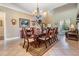 Elegant dining room with a chandelier, hardwood table and chairs, and view of the living area at 3211 Grassglen Pl, Wesley Chapel, FL 33544