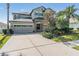 Two-story home exterior featuring a two-car garage, manicured landscaping, and a concrete driveway at 3211 Grassglen Pl, Wesley Chapel, FL 33544