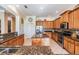Kitchen featuring wooden cabinetry, granite countertops, stainless steel appliances, and an island at 3211 Grassglen Pl, Wesley Chapel, FL 33544