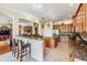 Open concept kitchen with granite countertops, wooden cabinets, tile floors, and a breakfast bar at 3211 Grassglen Pl, Wesley Chapel, FL 33544