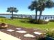 Landscaped backyard features palm trees, stepping stones, and a private dock on the serene waterfront at 362 Coquina Dr, Tarpon Springs, FL 34689