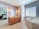 Primary bathroom featuring a soaking tub, wooden vanity, and neutral tile flooring at 362 Coquina Dr, Tarpon Springs, FL 34689