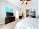 Bright bedroom featuring a queen-size bed, ceiling fan, and en suite closet and bathroom at 362 Coquina Dr, Tarpon Springs, FL 34689