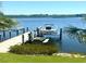 Boat dock with a boat lift, lush greenery, and clear waters providing direct access for water activities at 362 Coquina Dr, Tarpon Springs, FL 34689