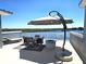 Spacious patio with seating area, sun umbrella, and fire pit, offering stunning water views at 362 Coquina Dr, Tarpon Springs, FL 34689