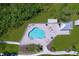 Aerial view of a kidney-shaped pool surrounded by lush landscaping and lounge chairs at 362 Coquina Dr, Tarpon Springs, FL 34689