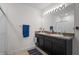 Bathroom featuring a double sink vanity with dark wood cabinets and a large, well-lit mirror at 36734 Goffaux Loop, Zephyrhills, FL 33541