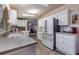Well-lit kitchen with neutral countertops, stone-look floors and stainless steel appliances at 37539 Landis Ave, Zephyrhills, FL 33541