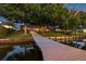 Beautiful home featuring a backyard with a wooden dock, waterfront access, and manicured lawn at 3829 Eagleflight Ln, Land O Lakes, FL 34639