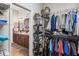 Organized walk-in closet leading to bathroom; wire racks with clothing and bathroom vanity at 3829 Eagleflight Ln, Land O Lakes, FL 34639