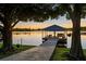An idyllic dock with a covered sitting area provides a perfect spot to enjoy waterfront views and tranquil sunsets at 3829 Eagleflight Ln, Land O Lakes, FL 34639