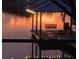 Covered dock with string lights, offering a cozy waterfront retreat with a swing and serene lake views at 3829 Eagleflight Ln, Land O Lakes, FL 34639