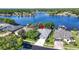 Aerial view of a lakeside home featuring lush landscaping, a well-manicured lawn, and a charming two-car garage at 3829 Eagleflight Ln, Land O Lakes, FL 34639