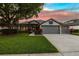 Charming home with a well-manicured lawn, two car garage, and lush landscaping at 3829 Eagleflight Ln, Land O Lakes, FL 34639