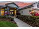 Home entryway with a paved walkway, lush landscaping, and a welcoming double door entrance at dusk at 3829 Eagleflight Ln, Land O Lakes, FL 34639