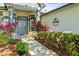 Elegant entryway with a paved walkway, lush landscaping, and a welcoming double door entrance at 3829 Eagleflight Ln, Land O Lakes, FL 34639