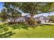 Beautifully landscaped home featuring lush green lawn, mature trees, and a well maintained exterior at 3829 Eagleflight Ln, Land O Lakes, FL 34639