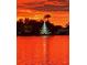 Beautiful sunset view with a lit Christmas tree reflecting on the serene lake at 3829 Eagleflight Ln, Land O Lakes, FL 34639