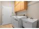 Bright laundry room with washer, dryer, utility sink, and overhead cabinets at 3829 Eagleflight Ln, Land O Lakes, FL 34639