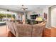 Comfortable living room with a large sofa, hardwood floors, and views of the pool at 3829 Eagleflight Ln, Land O Lakes, FL 34639
