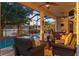 Inviting screened patio with comfortable seating, ceiling fan, and views of the pool and lake at dusk at 3829 Eagleflight Ln, Land O Lakes, FL 34639