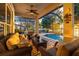 Inviting screened patio with comfortable seating, ceiling fan, and views of the pool and lake at 3829 Eagleflight Ln, Land O Lakes, FL 34639