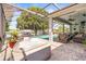 Enclosed patio area featuring a hot tub, pool, seating, and picturesque lake views at 3829 Eagleflight Ln, Land O Lakes, FL 34639