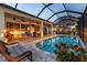 Beautiful screened pool area featuring waterfront views, patio seating, and clear glass doors to the home at 3829 Eagleflight Ln, Land O Lakes, FL 34639