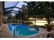 A screened-in pool offers a serene escape with lake views, complemented by lush landscaping for added privacy at 3829 Eagleflight Ln, Land O Lakes, FL 34639