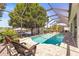 Beautiful pool area with a screened enclosure, overlooking a serene lake setting at 3829 Eagleflight Ln, Land O Lakes, FL 34639