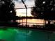 A tranquil pool area at dusk shows a serene lake view and a private retreat for relaxation and enjoyment at 3829 Eagleflight Ln, Land O Lakes, FL 34639