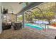 Inviting screened-in patio with pool, comfortable seating, and a serene lake view at 3829 Eagleflight Ln, Land O Lakes, FL 34639