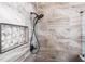 Close up of a shower with gray stone tiles and rock accents in alcove at 3829 Eagleflight Ln, Land O Lakes, FL 34639