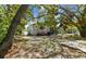 View of the home's gray exterior with a fenced yard filled with leaves and a few trees and bushes at 412 E Columbus Dr, Tampa, FL 33602