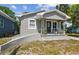 Charming single-story home featuring a gray exterior, quaint front porch, and well-maintained landscaping at 412 E Columbus Dr, Tampa, FL 33602