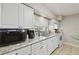 Well-lit kitchen featuring granite countertops and white cabinetry at 412 E Columbus Dr, Tampa, FL 33602