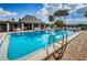 Sparkling community pool with ample seating, palm trees, and a clubhouse for residents' enjoyment at 4242 Sheldon Pl, New Port Richey, FL 34652