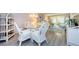 Elegant dining area featuring a glass-top table, white wicker chairs, and modern lighting fixtures at 4242 Sheldon Pl, New Port Richey, FL 34652