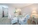 Cozy dining room with a glass table, white wicker chairs, and soft lighting for a relaxed atmosphere at 4242 Sheldon Pl, New Port Richey, FL 34652