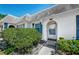 Charming home featuring a white exterior, arched doorway and blue shutters surrounded by mature landscaping at 4242 Sheldon Pl, New Port Richey, FL 34652
