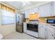 Bright kitchen featuring white cabinets, stainless steel refrigerator, and tile backsplash at 4242 Sheldon Pl, New Port Richey, FL 34652