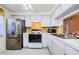 Well-lit kitchen with stainless steel appliances, white cabinetry, and tile backsplash at 4242 Sheldon Pl, New Port Richey, FL 34652